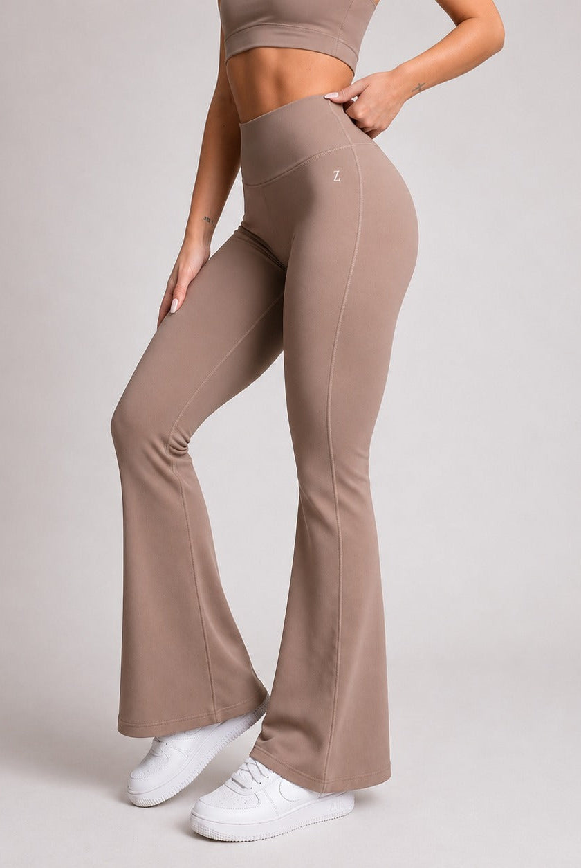 Stylish woman wearing flare leggings for women in a neutral color, paired with white sneakers.