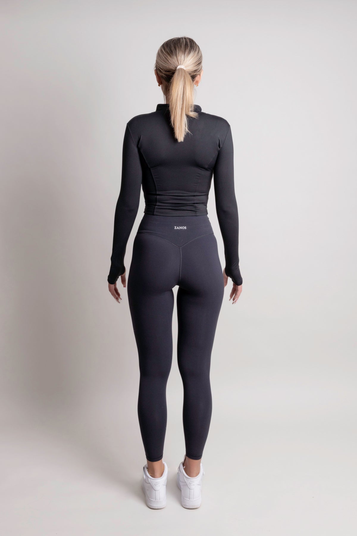 NOIR zip jacket black women seen from the back, showcasing a sleek silhouette and lightweight fabric.