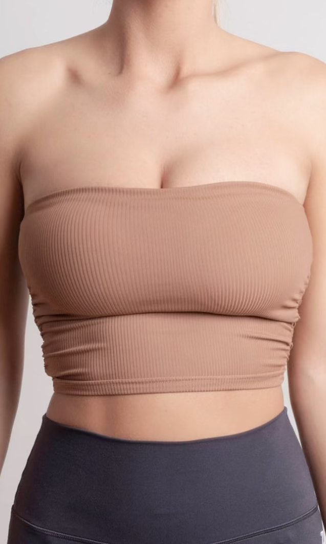 Brown strapless top worn by a person on a plain background