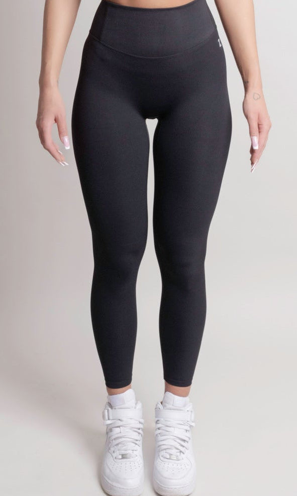 Person wearing NOIR Cloudfit Leggings Black black leggings and white sneakers on a plain background