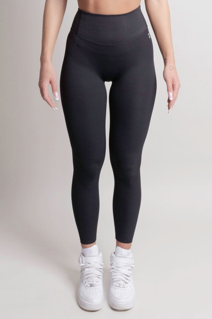 Person wearing NOIR Cloudfit Leggings Black black leggings and white sneakers on a plain background