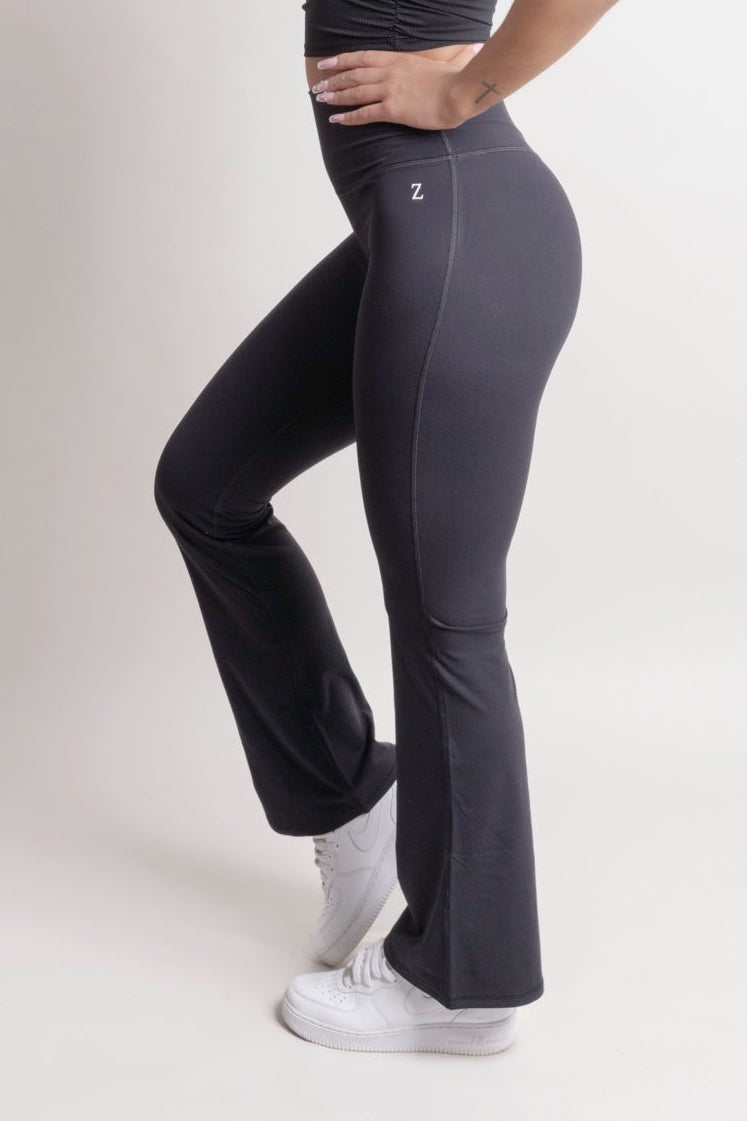 Model wearing NOIR Flare Pants Black showcasing a flattering fit and flared leg design, emphasizing a stylish silhouette.
