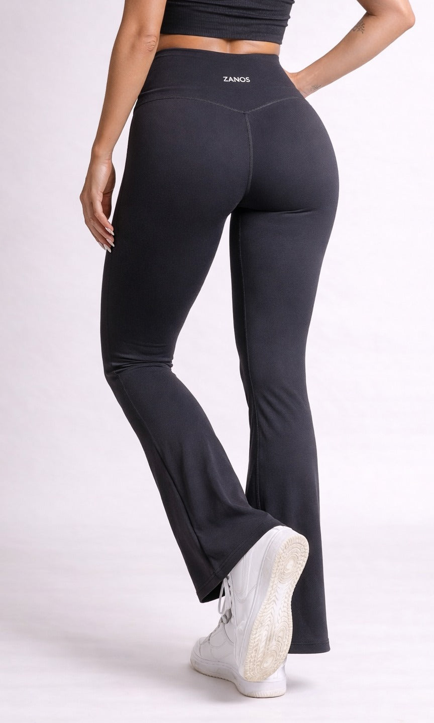 Person wearing black leggings with a visible brand logo on a white background