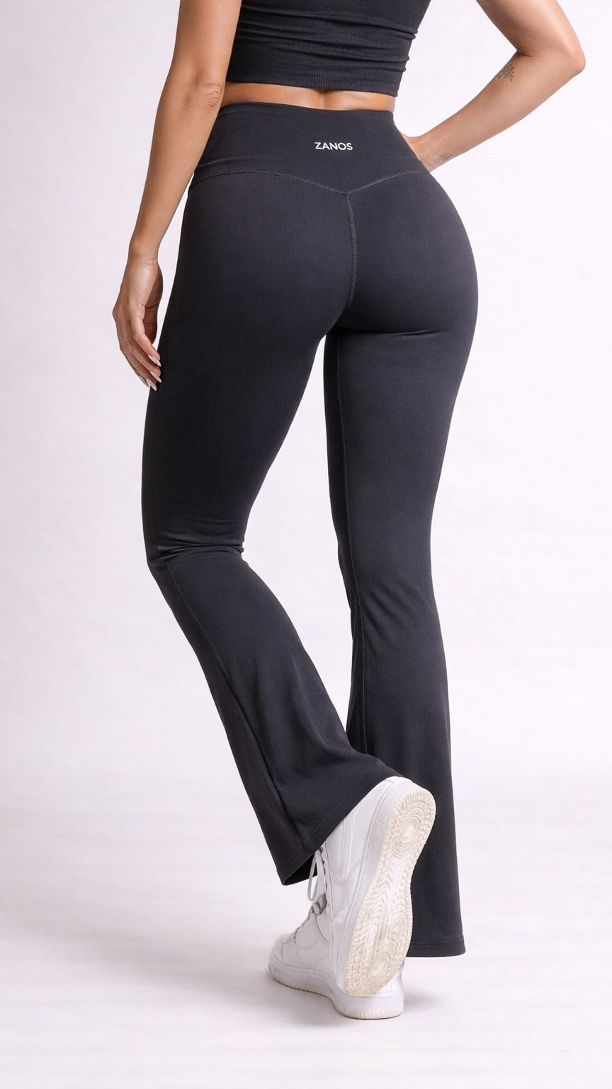 Person wearing black leggings with a visible brand logo on a white background