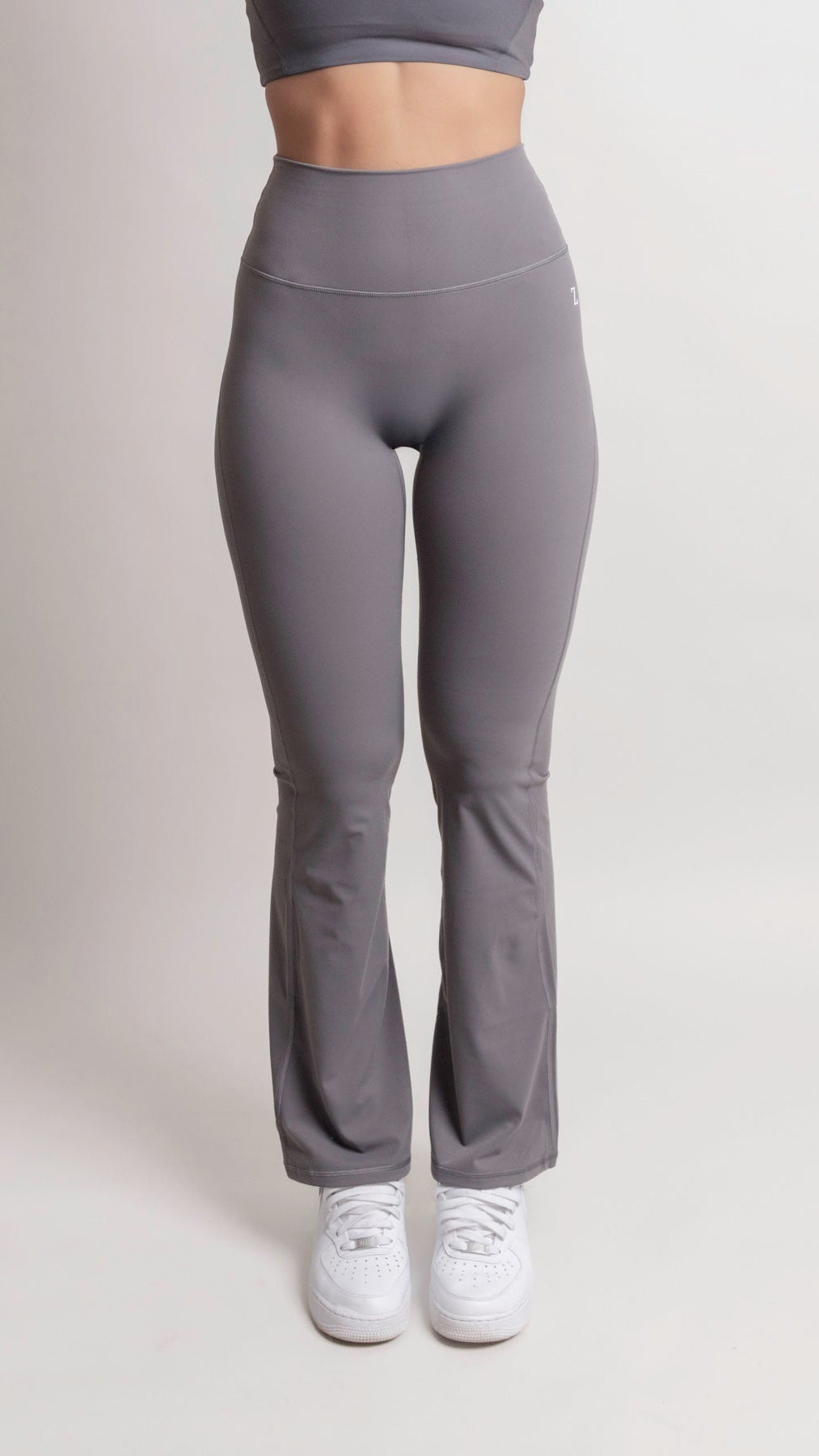 Model wearing NOIR Flare Pants Grey Women, high-waisted with a flared leg for an elongating silhouette.