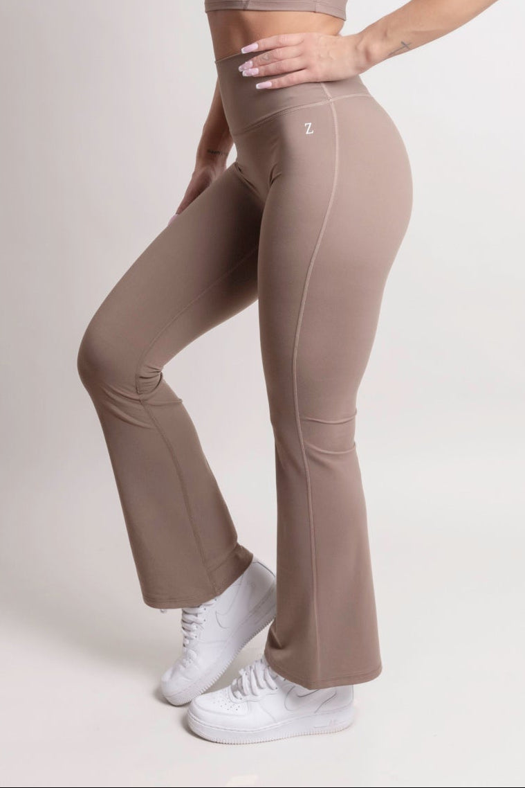 Woman wearing NOIR Flare Pants Brown with matching top, showcasing a flattering silhouette and stylish look.