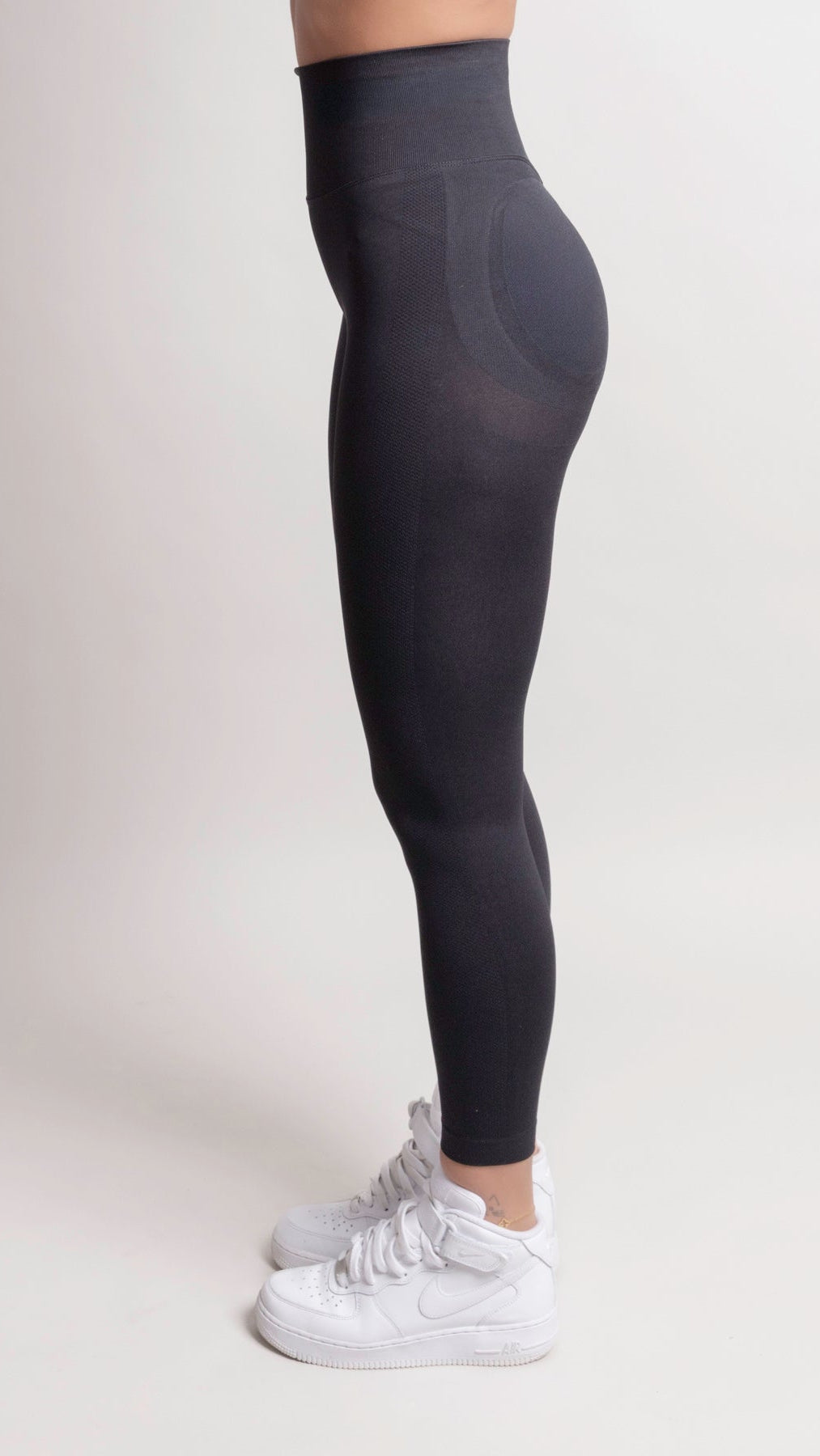 NOIR scrunch leggings black on a model showcasing a smooth body-hugging fit and flattering design from the side.