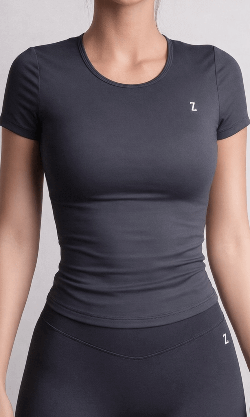 Person wearing a dark gray athletic outfit with a logo on a light gray background