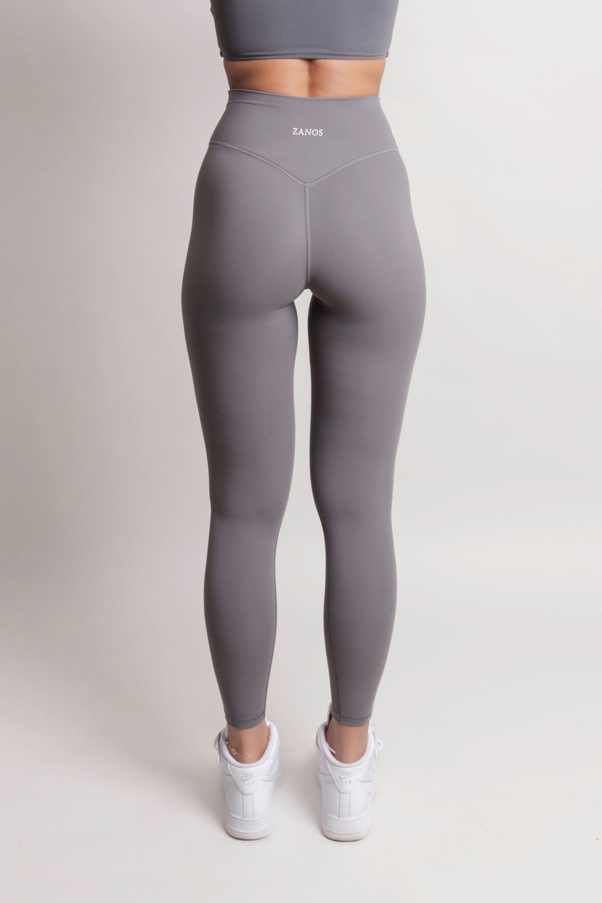 Gray leggings worn by a person on a white background