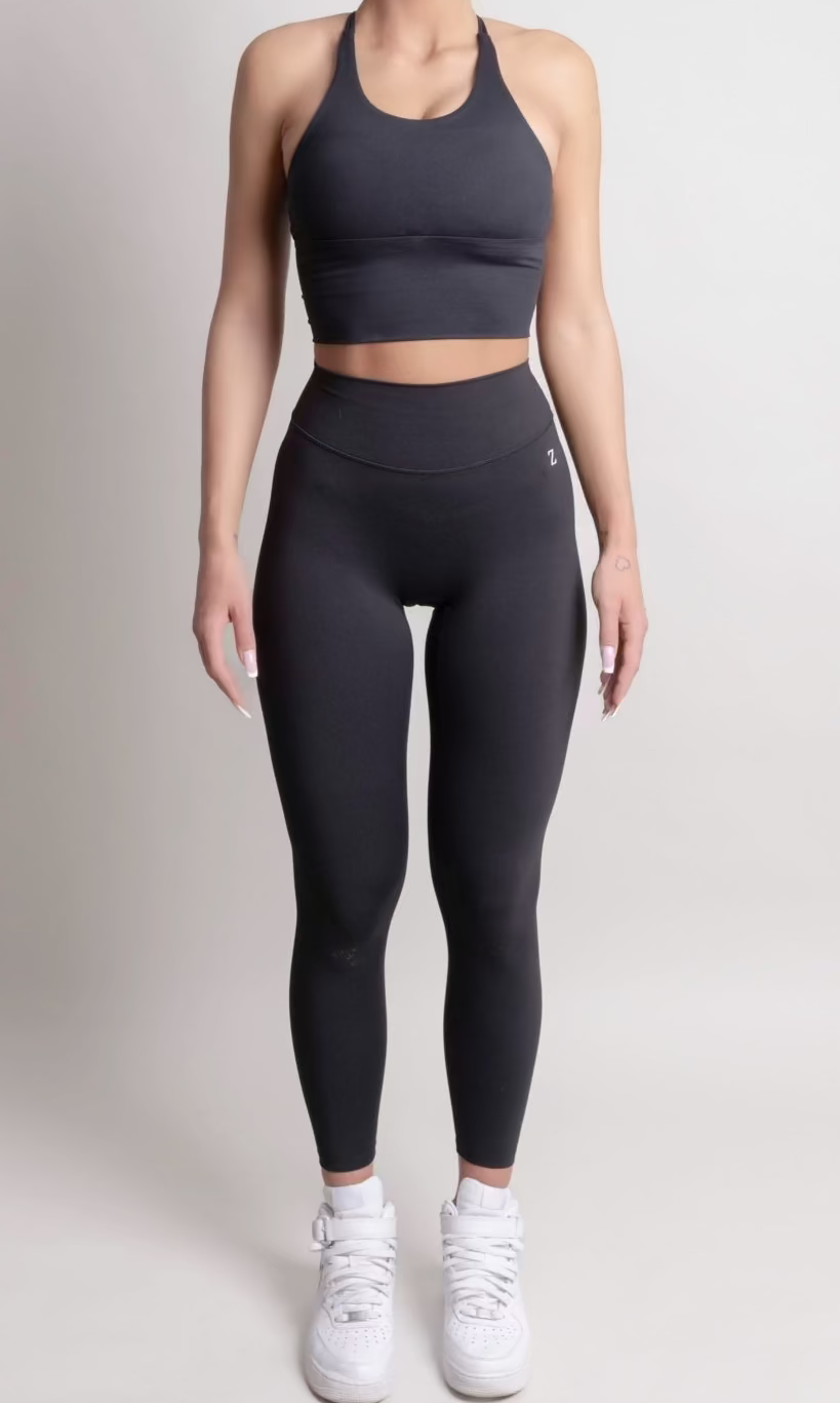 Woman wearing a black athletic outfit on a white background