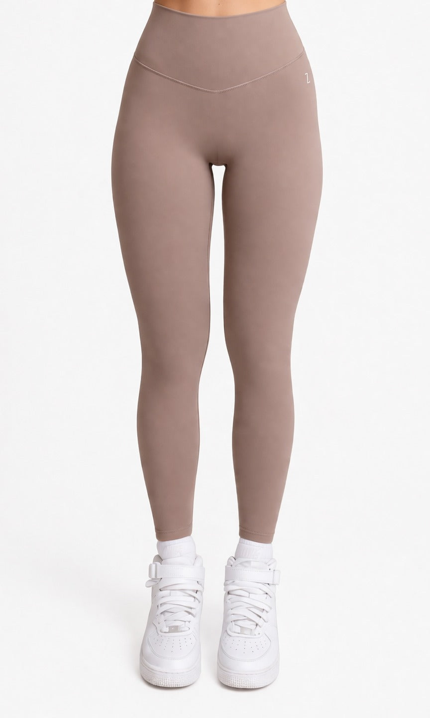 Woman wearing NOIR Yoga Leggings in Brown Mocha color with matching top, Front showcasing a flattering silhouette and stylish look.