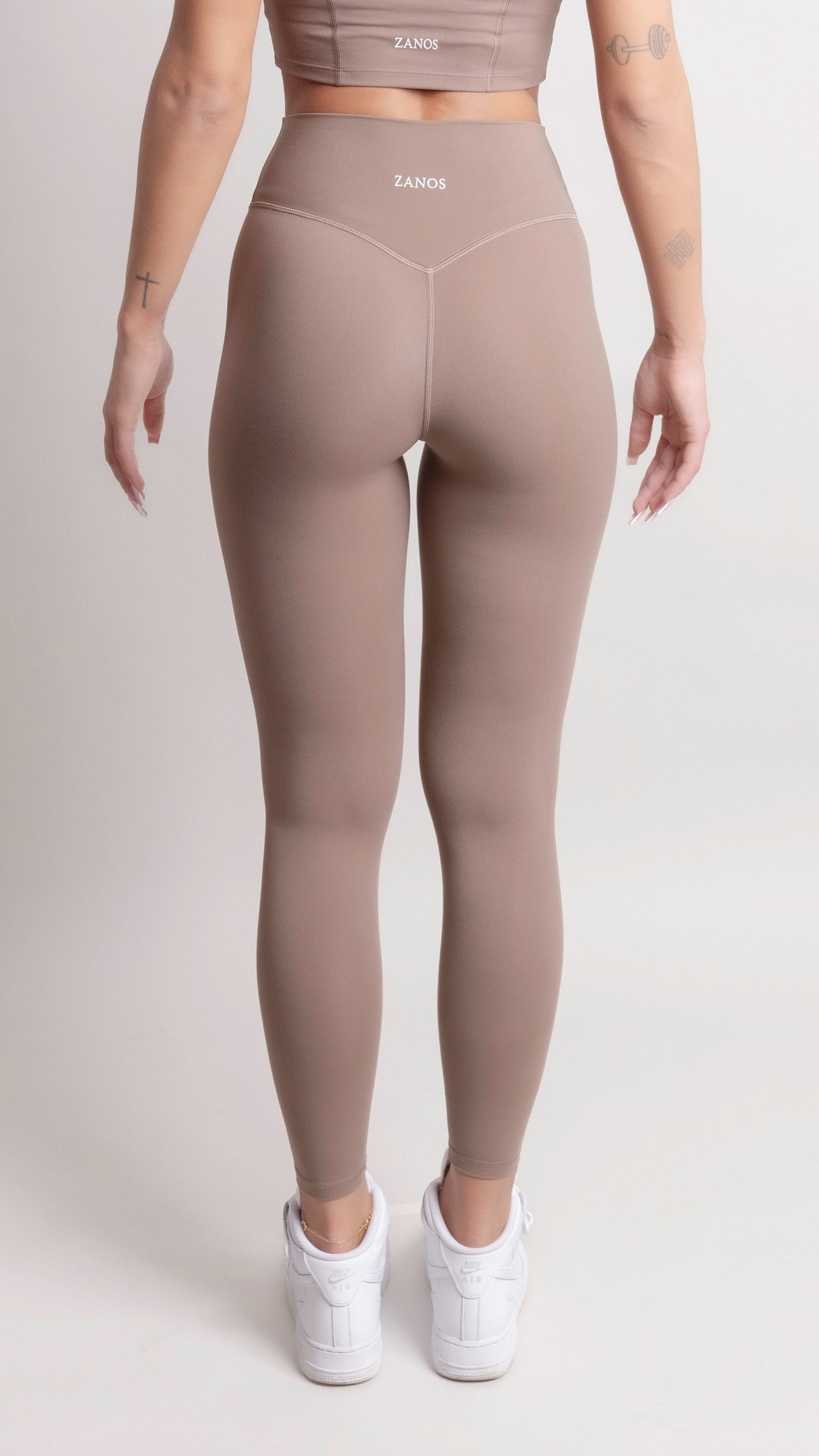 Model wearing NOIR Yoga Leggings Brown and matching top from the back, showcasing soft fabric and supportive fit.