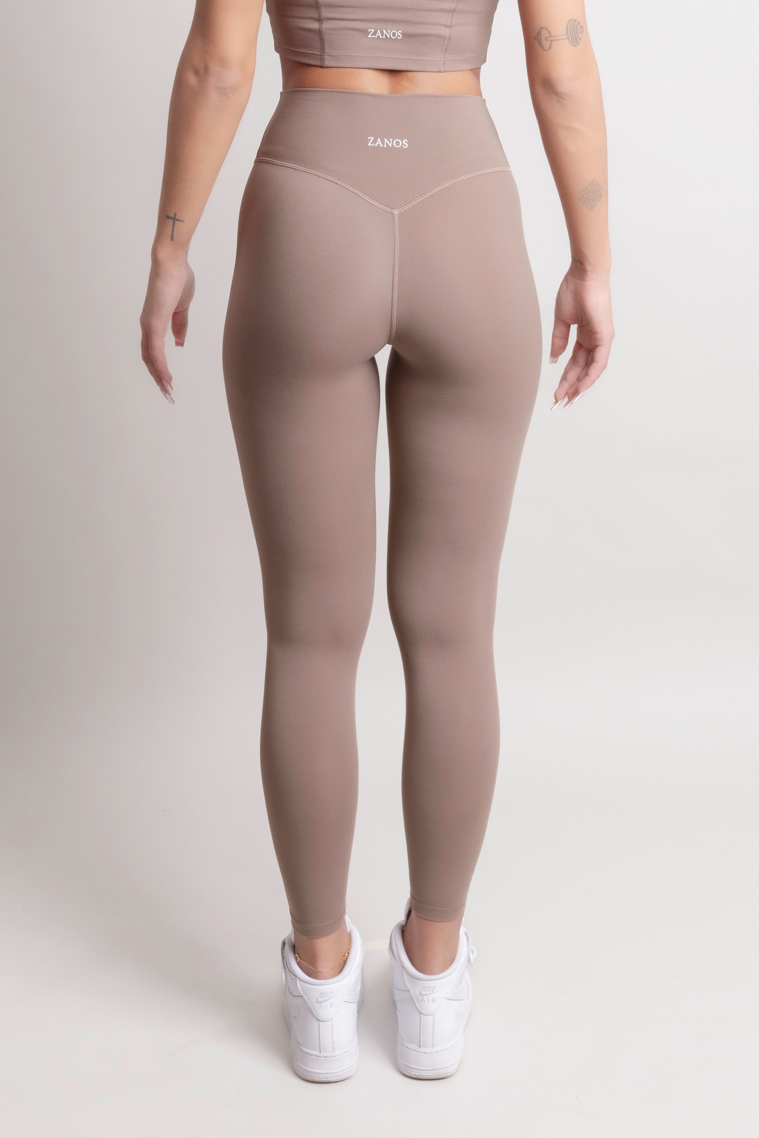Model wearing NOIR Yoga Leggings Brown and matching top from the back, showcasing soft fabric and supportive fit.