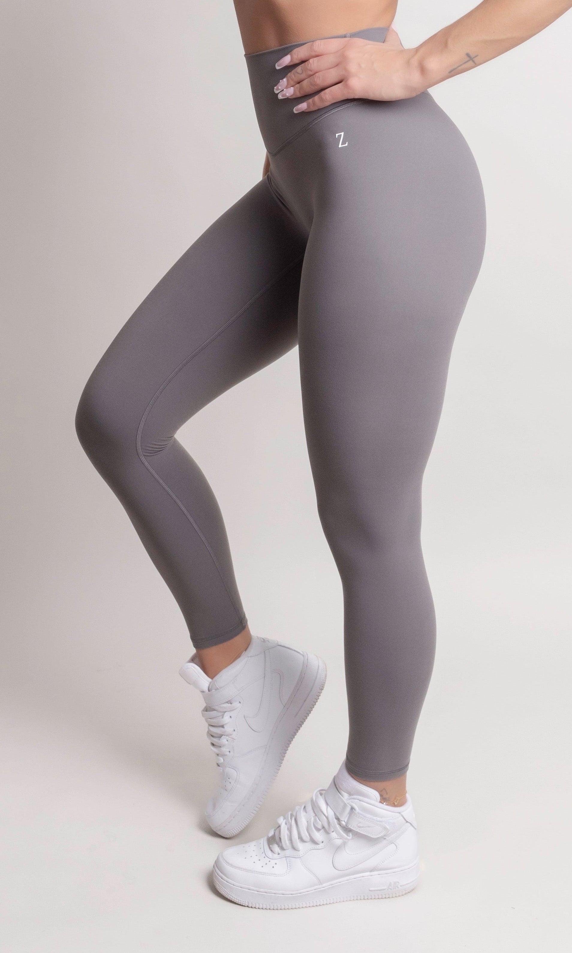Woman wearing NOIR yoga leggings grey with matching sports bra, showcasing comfort and support.