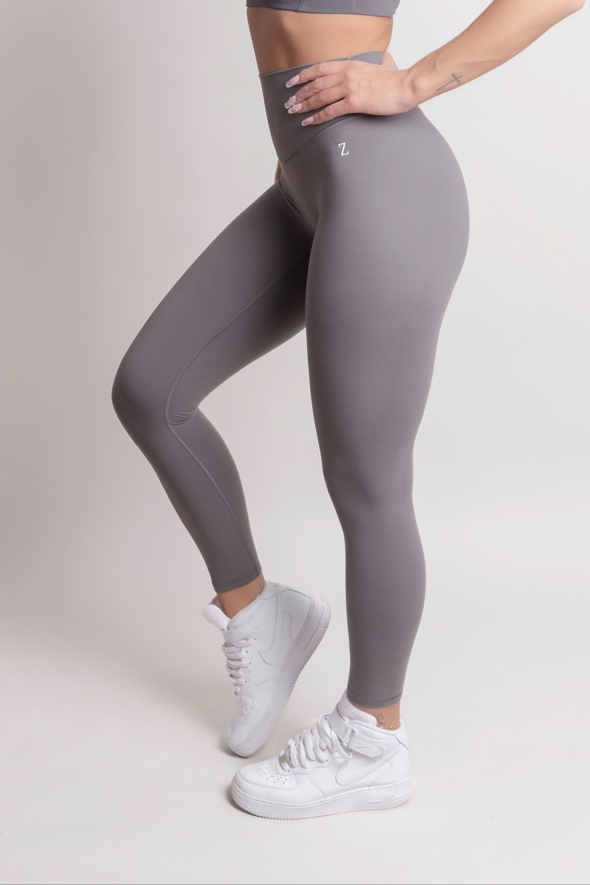 Woman wearing NOIR yoga leggings grey with matching sports bra, showcasing comfort and support.