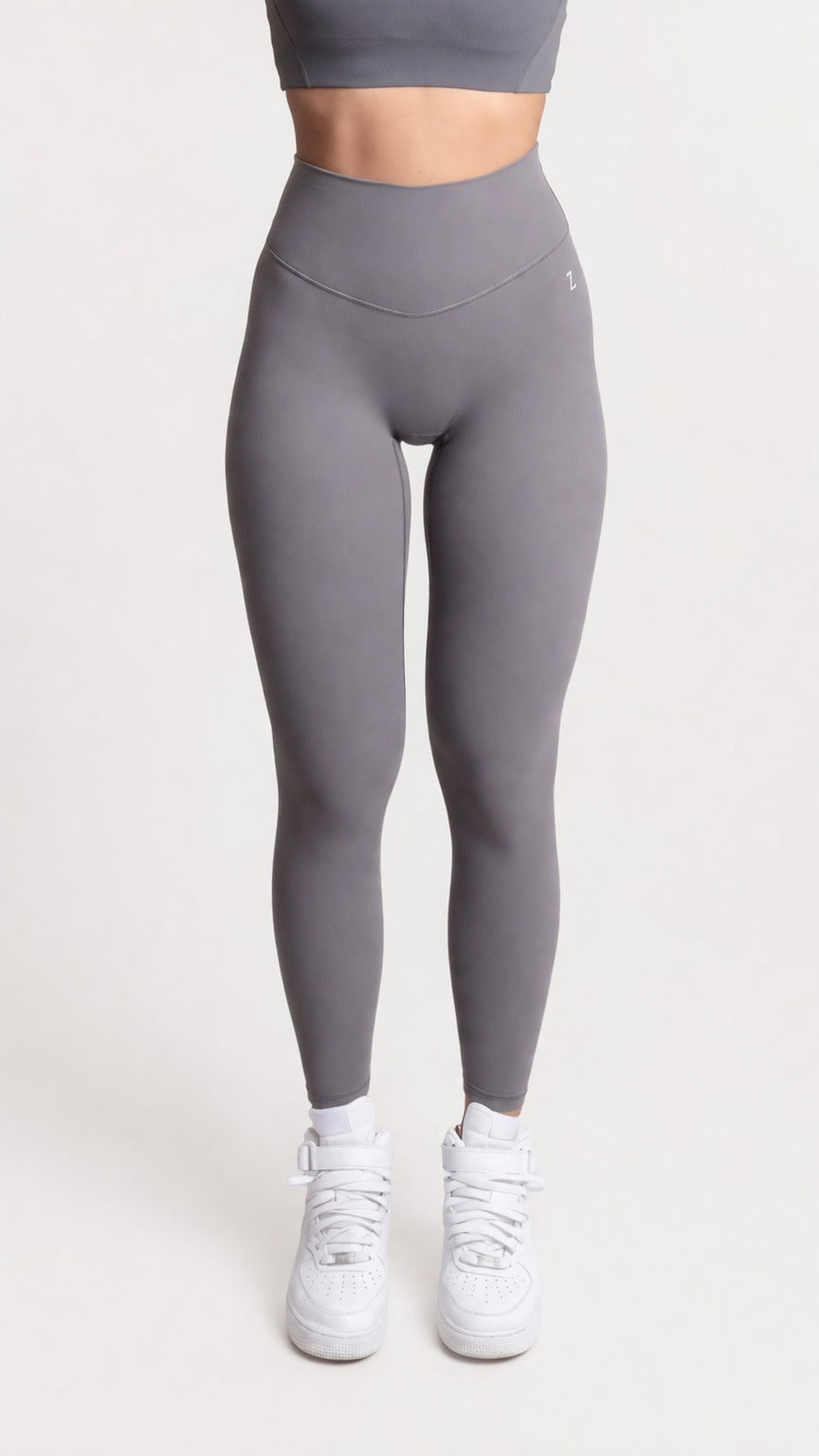 Woman wearing NOIR yoga leggings grey with matching sports bra, fron pose showcasing comfort and support.