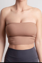 NOIR bandeau top earth brown model wearing seamless ribbed bandeau top, perfect for studio flow and summer nights.