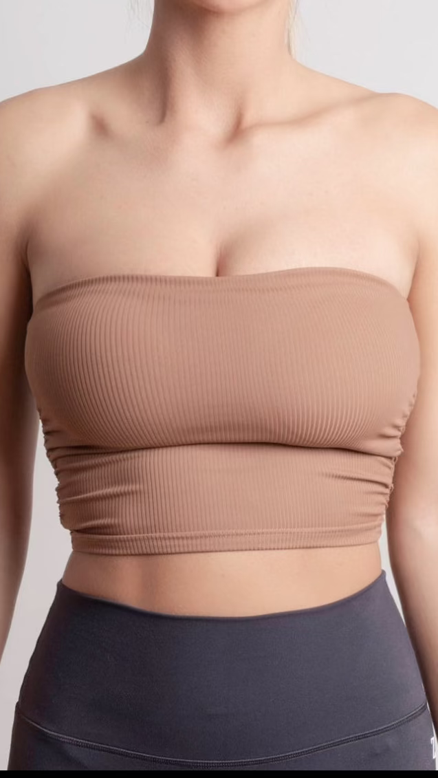 Brown strapless top worn by a person on a plain background