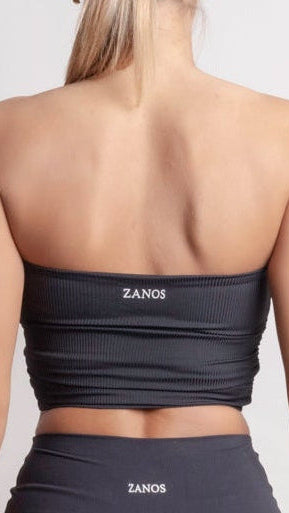 Person wearing a NOIR Bandeau Top black athletic outfit with visible branding on a white background