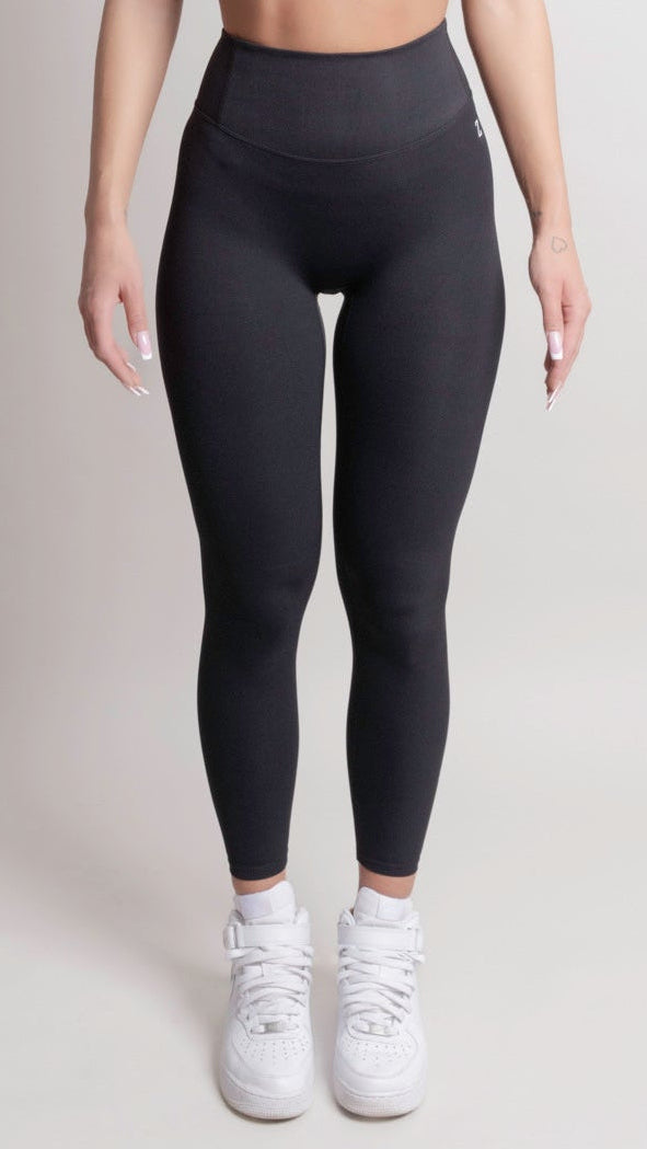 Person wearing NOIR Cloudfit Leggings Black black leggings and white sneakers on a plain background