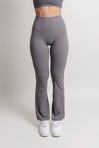 Model wearing NOIR Flare Pants Grey Women, high-waisted with a flared leg for an elongating silhouette.