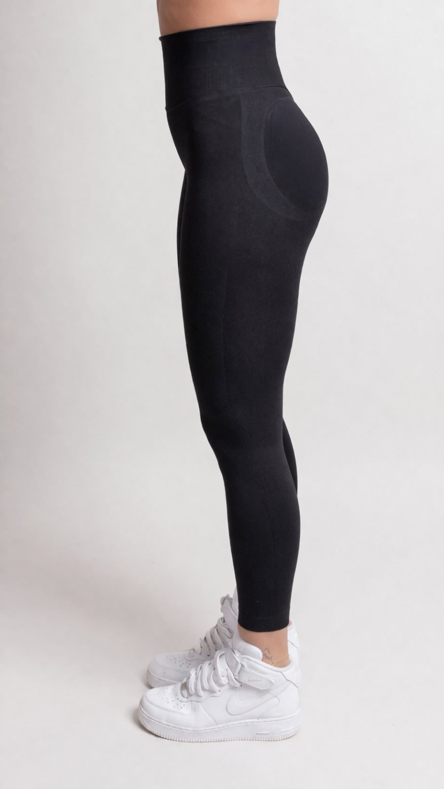 NOIR scrunch leggings black on a model showcasing a smooth body-hugging fit and flattering design from the side.