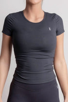 Woman wearing a NOIR t-shirt Black athletic outfit with a logo on a light gray background