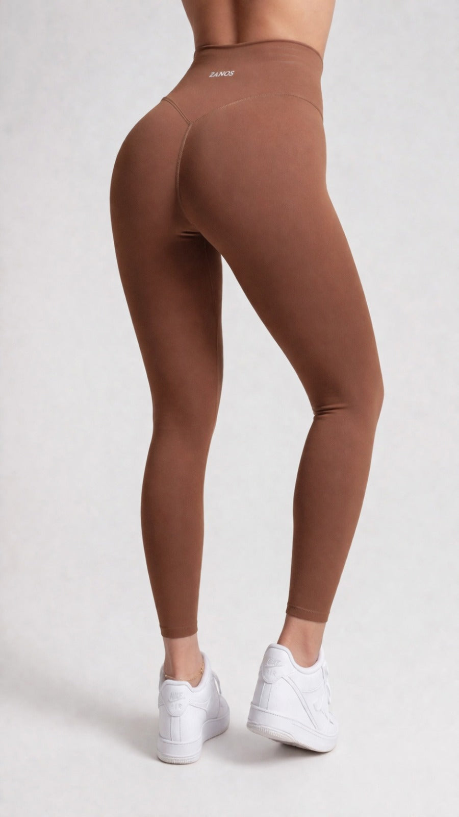 Brown leggings from zanos apparel worn by a person on a white background