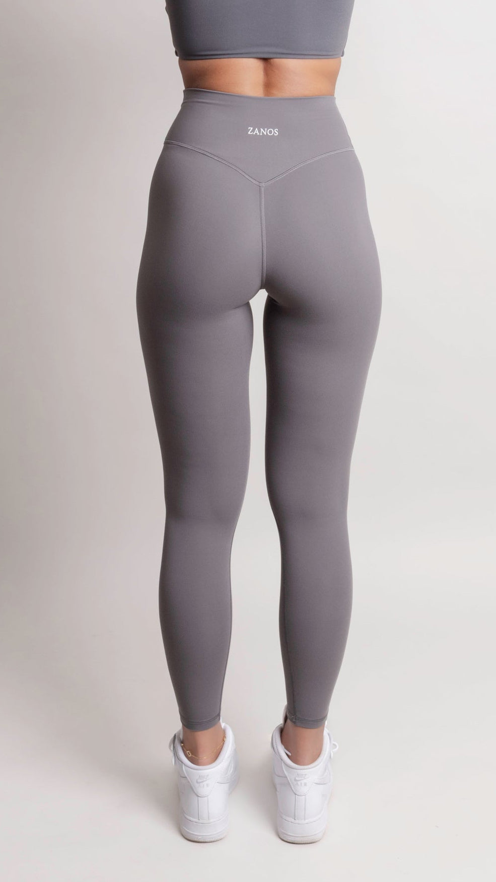 Gray leggings worn by a person on a white background