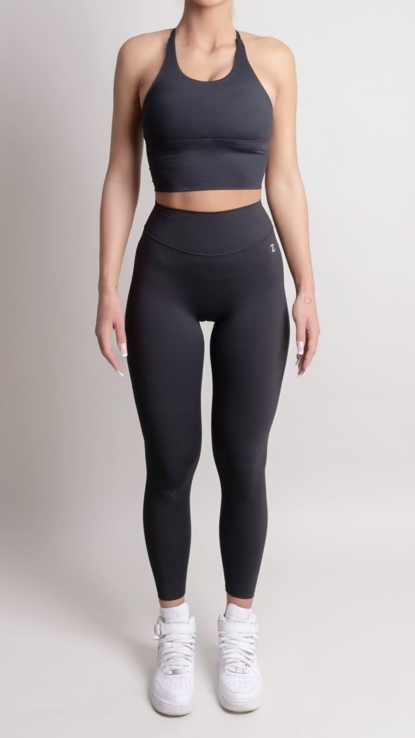 Woman wearing a black athletic outfit on a white background