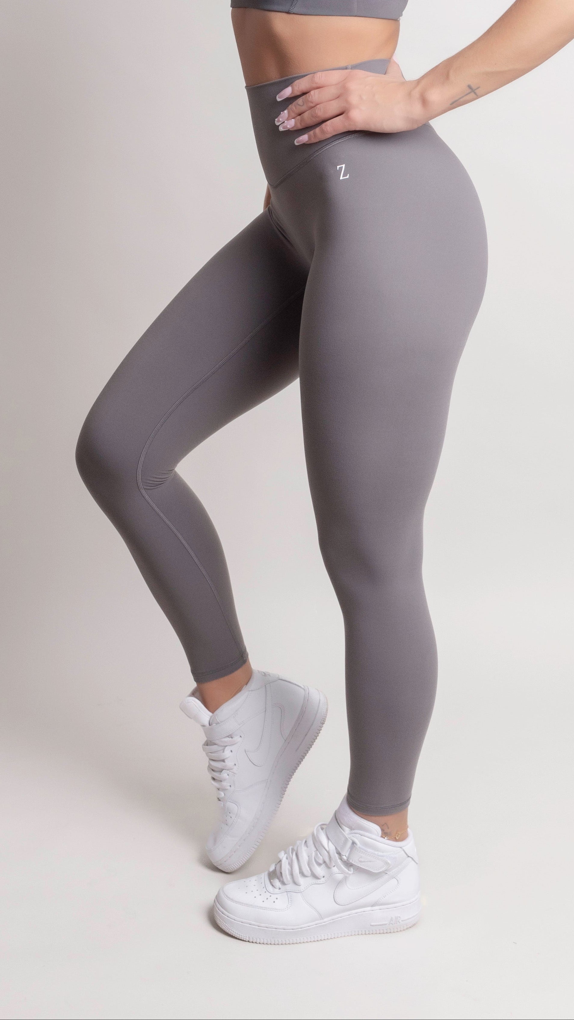 Woman wearing NOIR yoga leggings grey with matching sports bra, showcasing comfort and support.