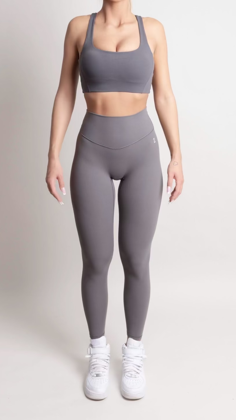 Woman wearing a gray athletic outfit on a white background