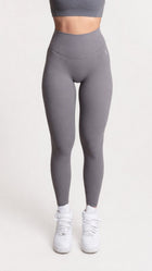 Woman wearing NOIR yoga leggings grey with matching sports bra, fron pose showcasing comfort and support.