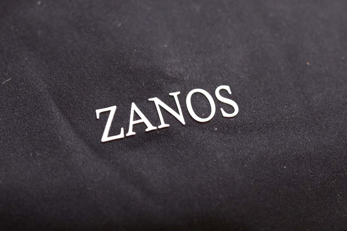 Text 'ZANOS' embossed on a black fabric surface