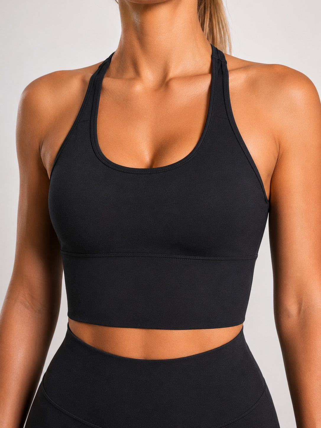 Woman wearing NOIR Cross Top in Black, side view.